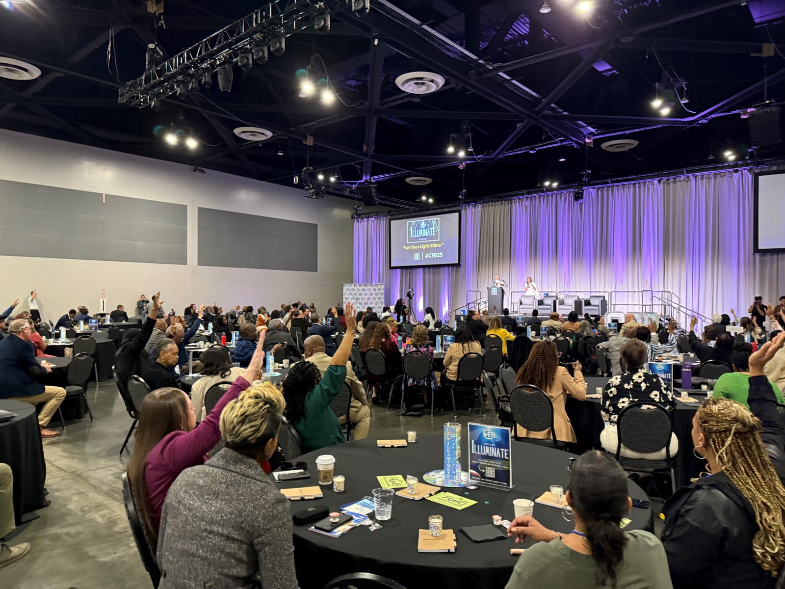 Business owners and partners raise their hands at an Entrepreneur Ecosystem event